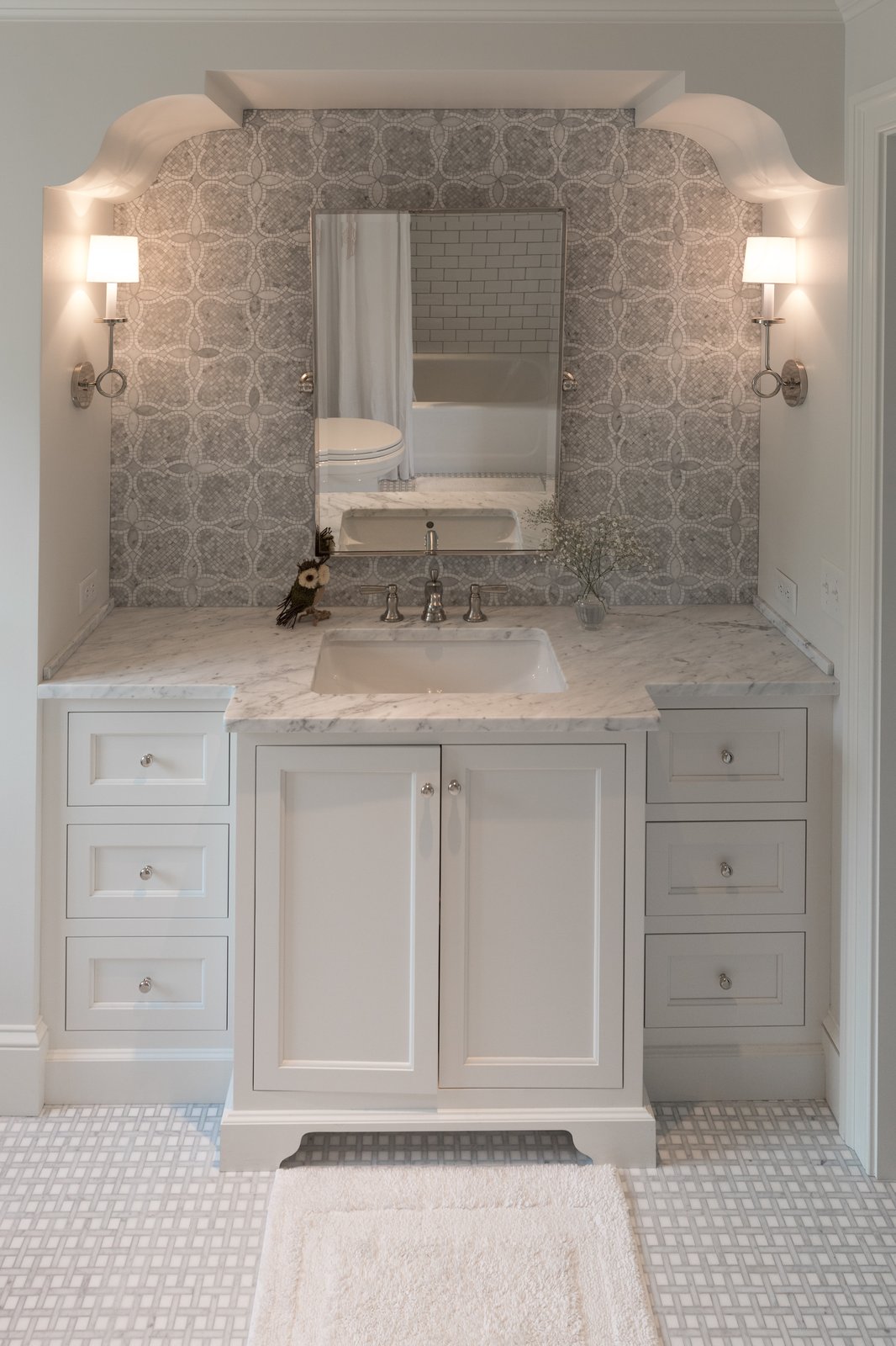 Powder room with white vanity and marble countertop