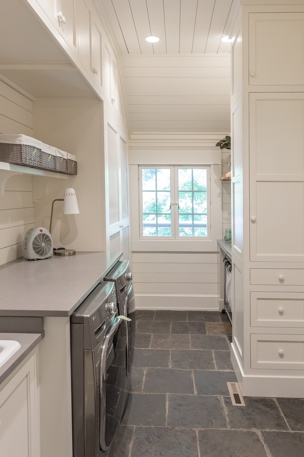 Narrow laundry room with floor to ceiling storage cabinets
